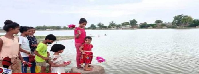Little hands shed dolls in water, Guddi Bolavani festival